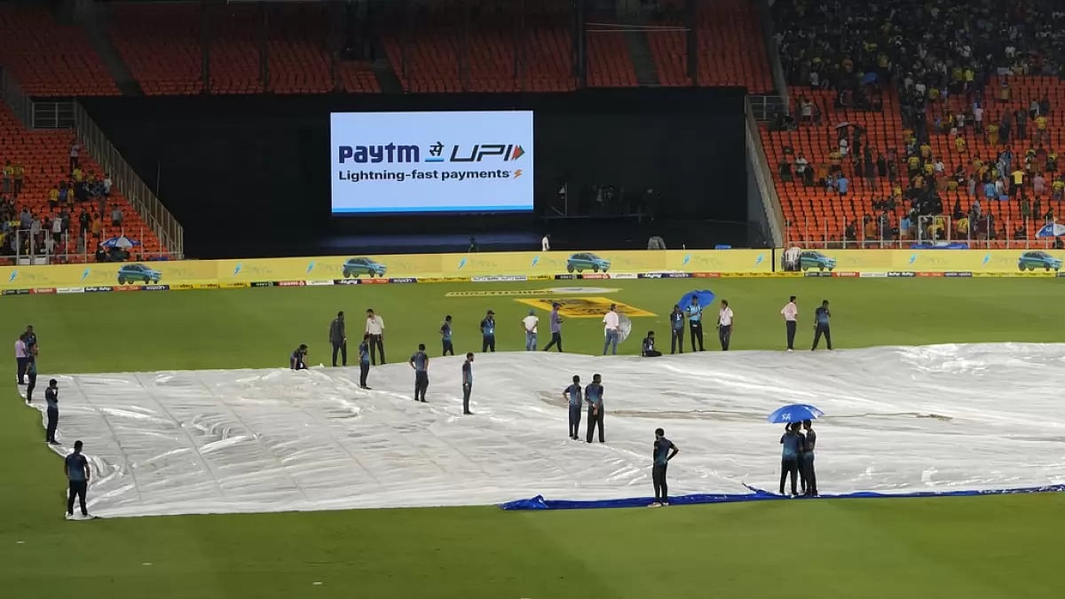 The pitch at the Narendra Modi Stadium is covered due to rain on Monday.