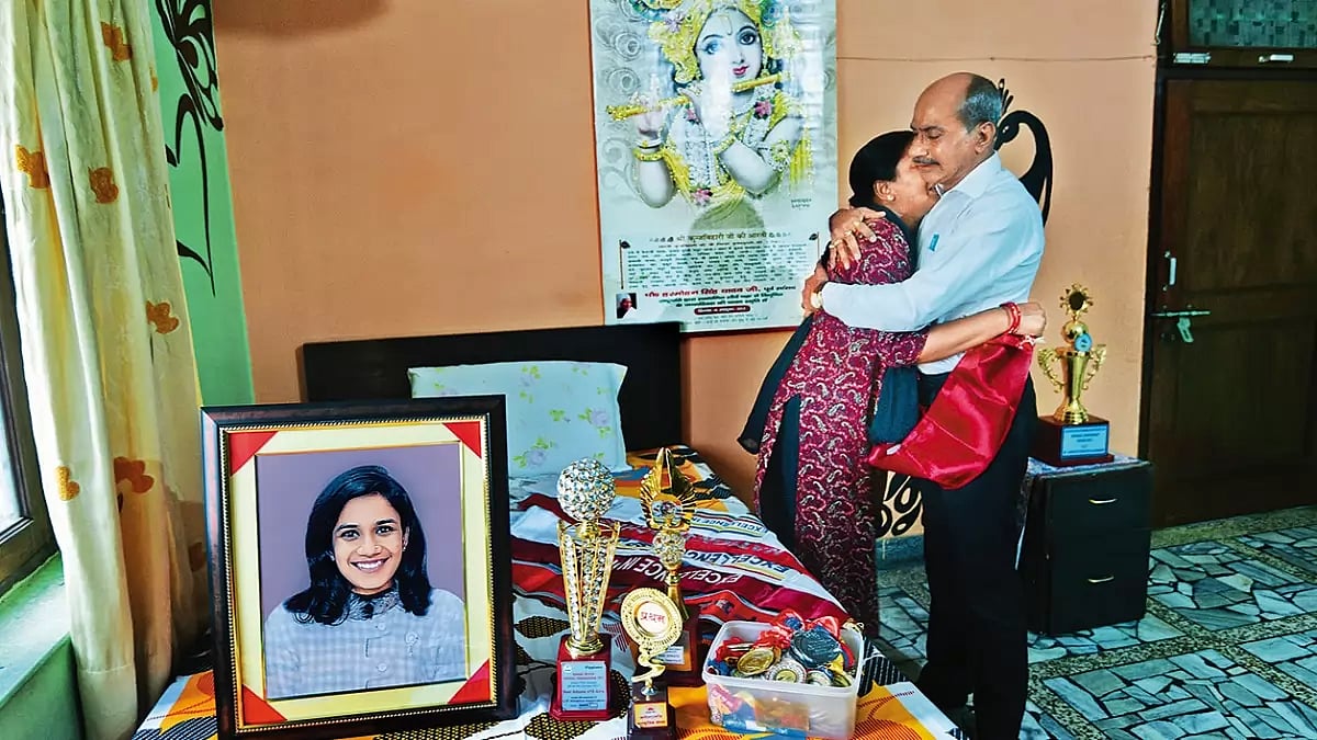 Among her Laurels: Sneha Chaurasiya’s parents hug each other next to her photograph