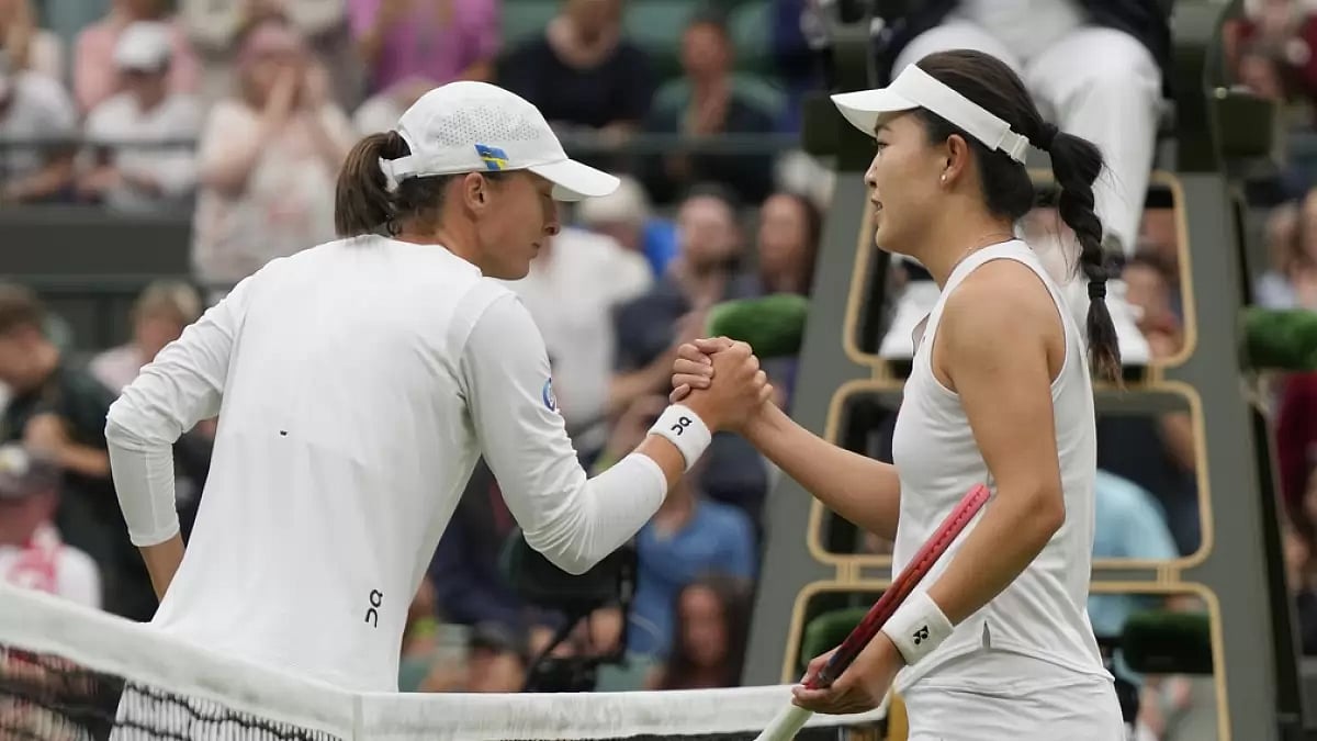 Swiatek is congratulated by Zhu Lin after their first-round match on Monday.