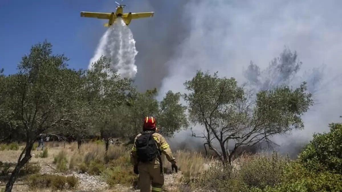 Aircraft dropping water over a wildfire in southeastern Greece.