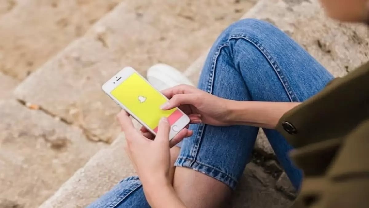 Woman using snapchat app on smartphone