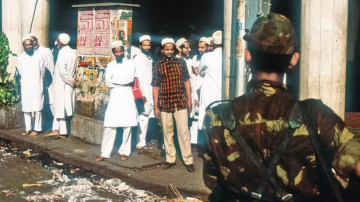 In Need of Protection: A soldier escorts Muslims down the street in Mumbai