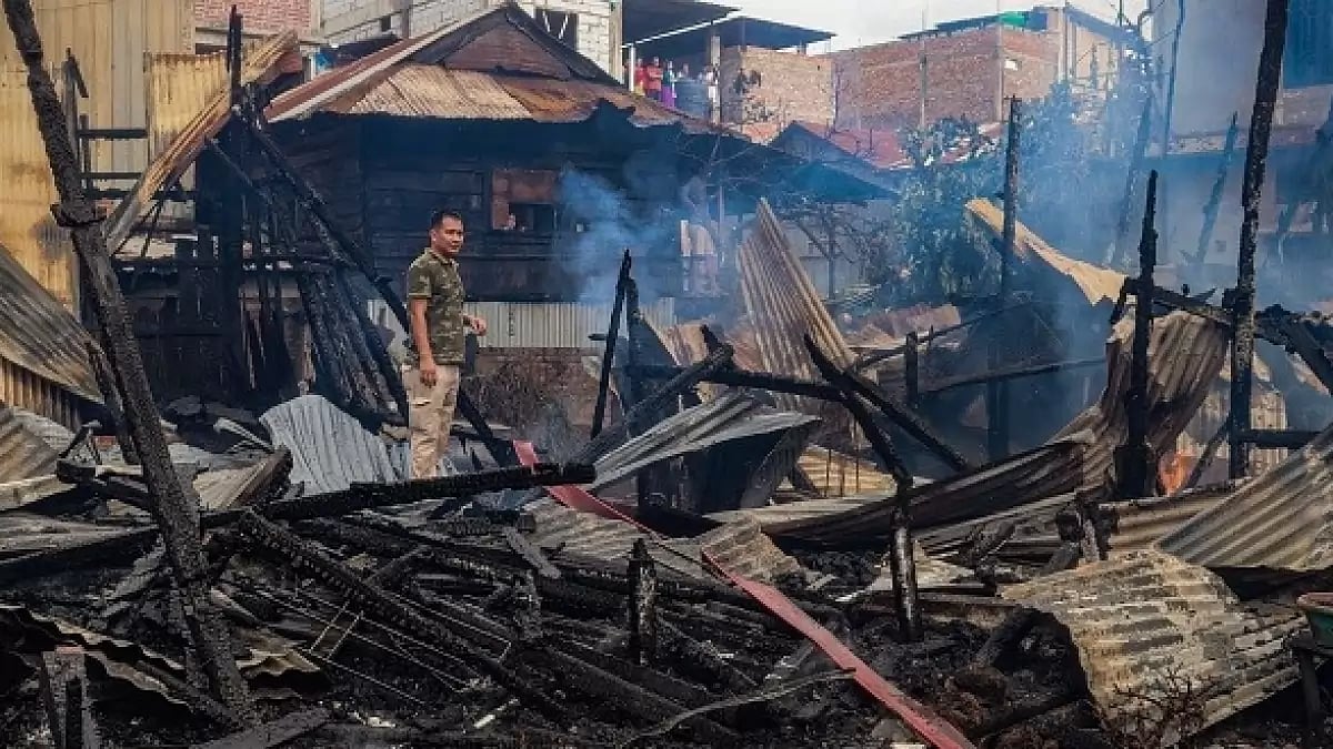 A man stands amid the charred remains of houses burned down in an suspected arson attack by unknown miscreants, following ongoing ethnic violence in Imphal. (Photo: Getty Images)