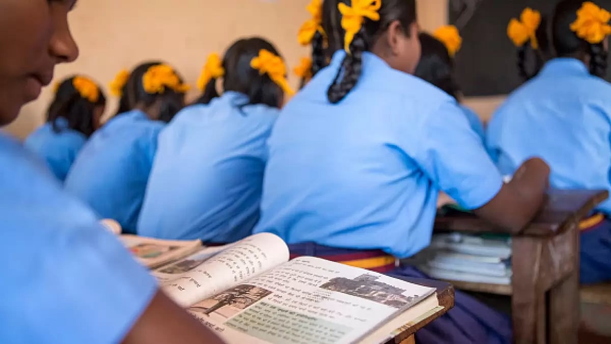 School girls in uniform are reading in their classroom in a school in Satia