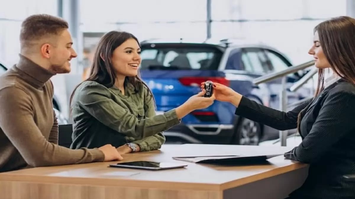 A couple receiving car keys from car showroom 