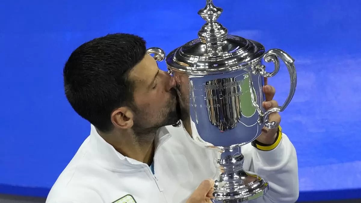 Novak Djokovic kisses championship trophy after defeating Daniil Medvedev.