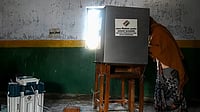 A voter casts her ballot at a polling station in Vrindavan on February 10, 2022 during the 1st Phase