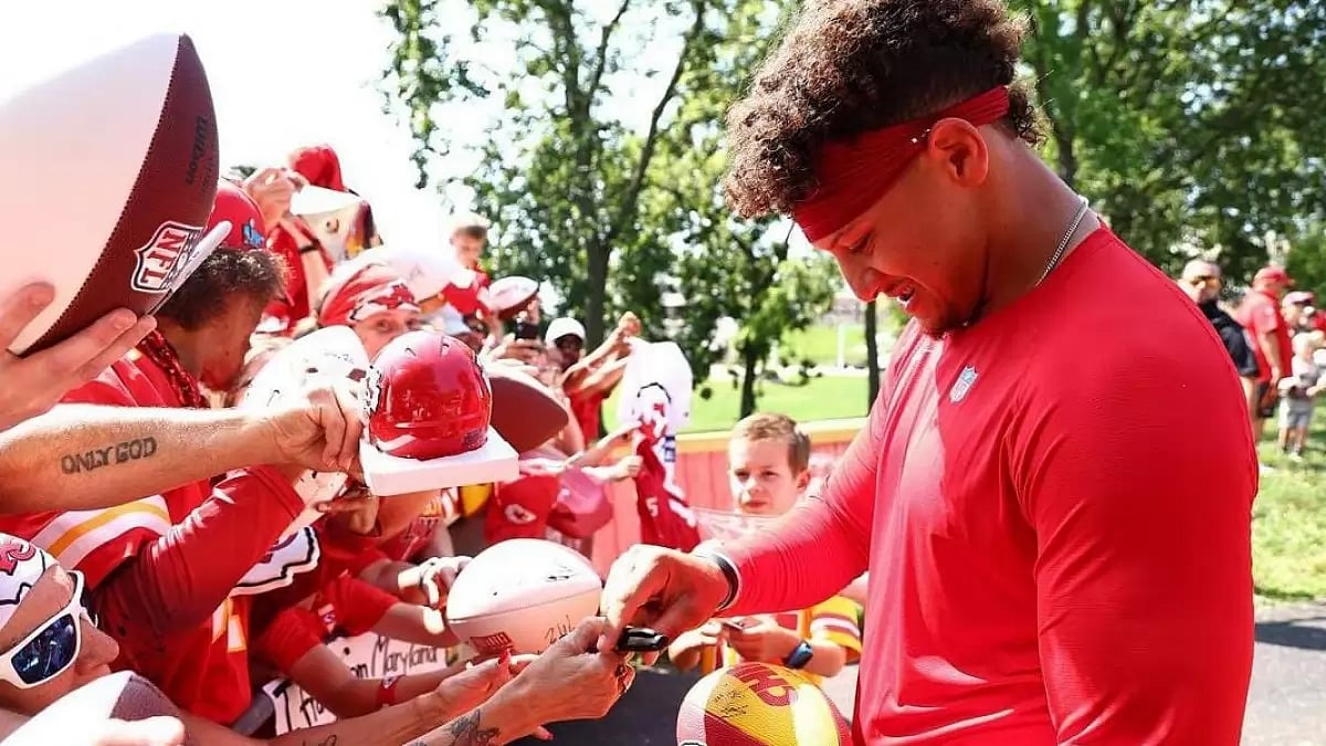 Patrick Mahomes giving autographs to a crowd full of fans 