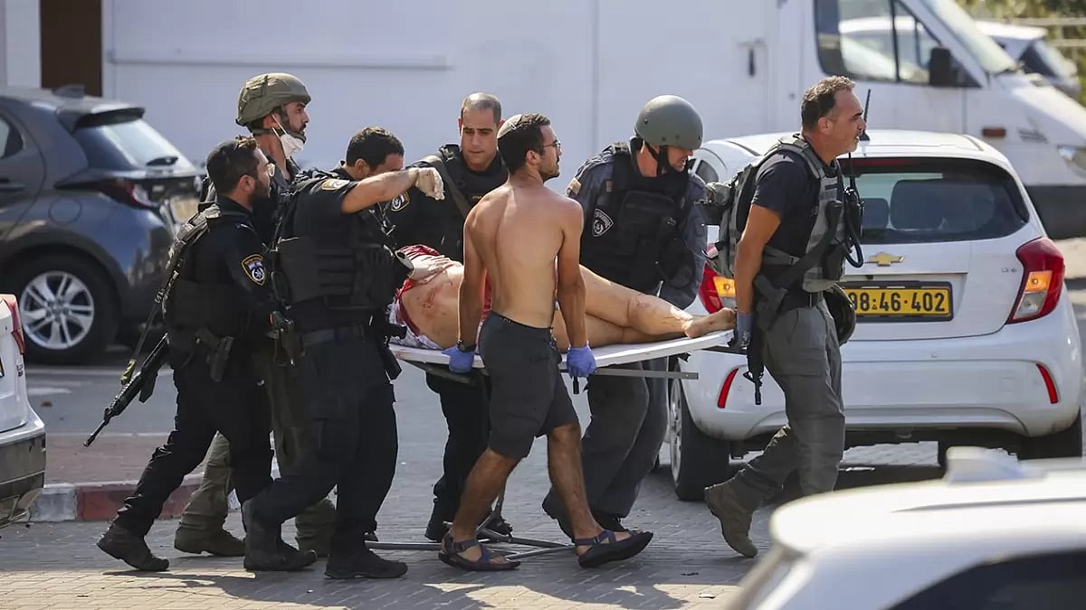 Israeli security forces evacuate an injured woman from a site hit by a rocket fired from the Gaza Strip, in Ashkelon, southern Israel.