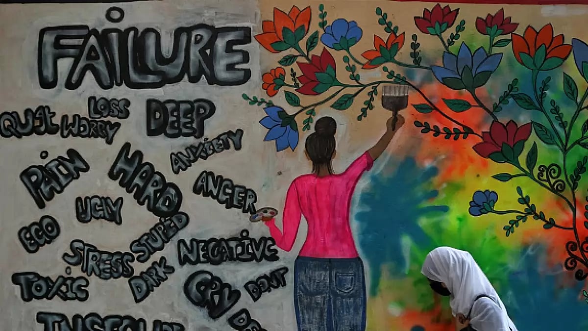 A college student walks past a graffiti on World Mental Health Day in Srinagar. - null