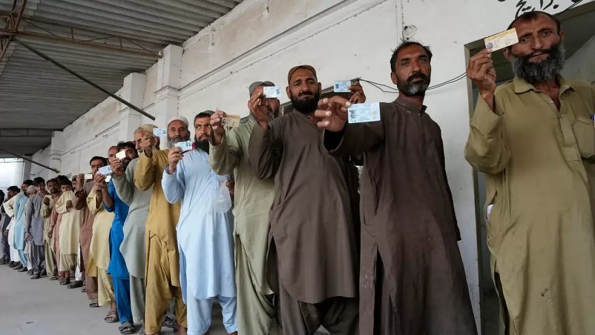People standing in a queue with their identity proof amid a deportation drive 