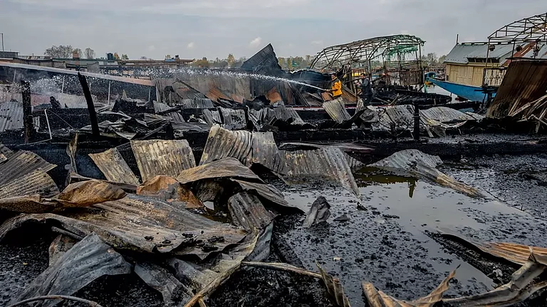Kashmiris work to douse a fire that gutted several houseboats early morning in the interiors of Dal Lake, on the outskirts of Srinagar, Kashmir. - null