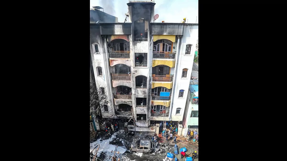Firefighters and police personnel at the site after a fire broke out at a multi-storeyed apartment complex in Nampally area, in Hyderabad. (PTI Photo)