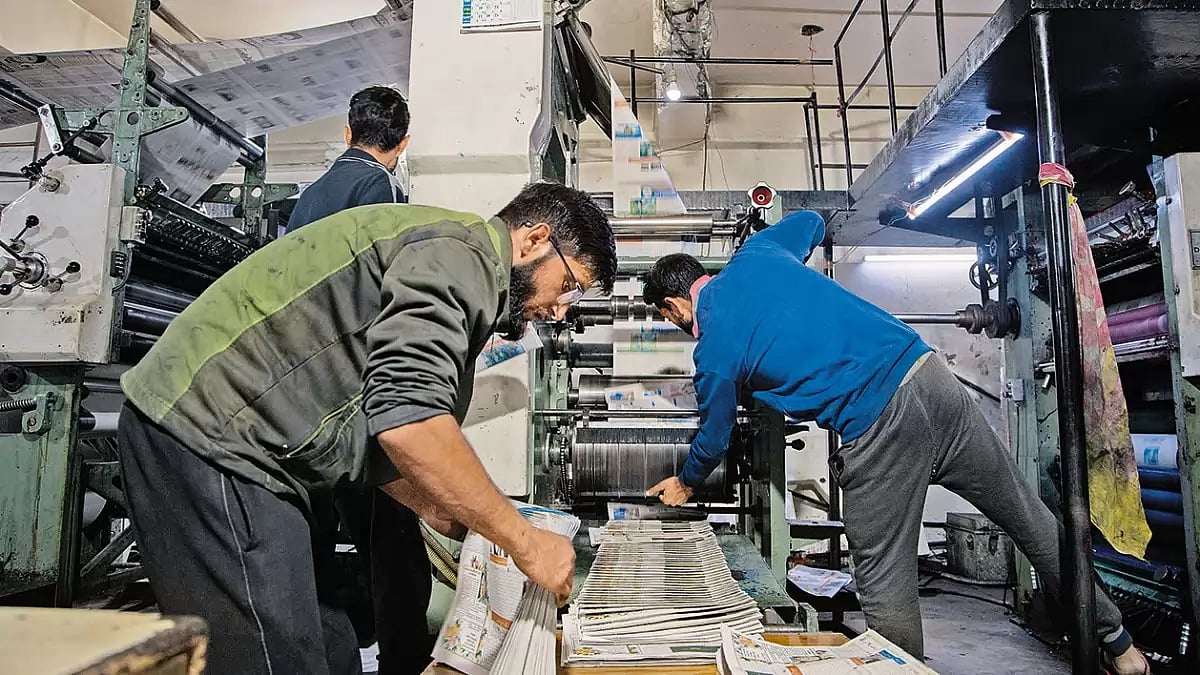 Workers at a printing press on a chilly November night in Srinagar