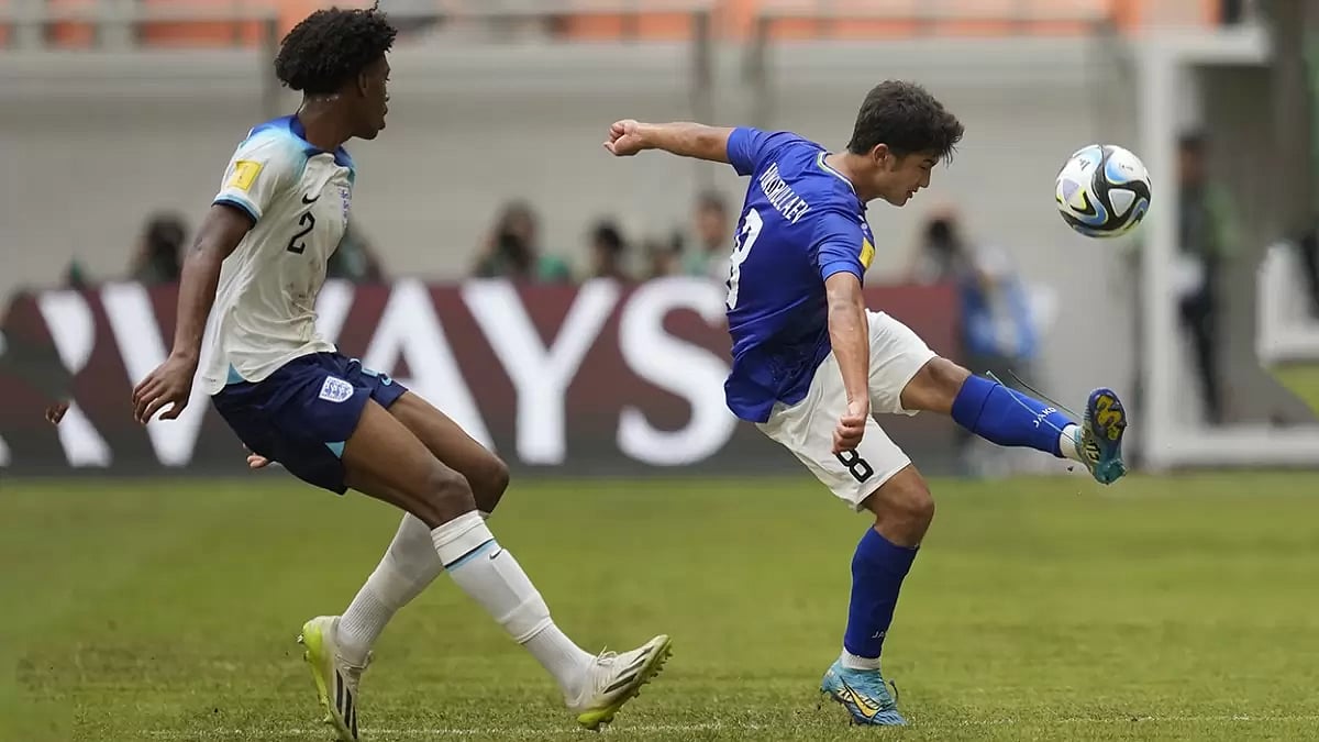 Uzbekistan's Bekhruz Shukurullaev, right, battles for the ball against England's Josh-Kofi Acheampong during their FIFA U-17 World Cup round of 16 football match in Jakarta, Indonesia.