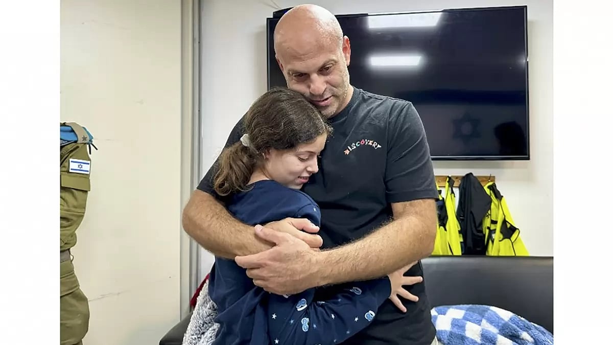 In this photo provided by the Israeli Army, Hila Rotem Shoshani, a released hostage, reunites with her uncle in Israel.