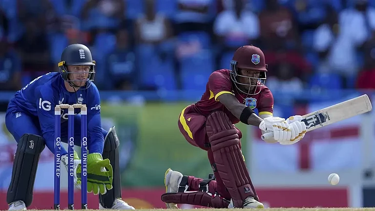 West Indies' Alick Athanaze plays a shot under the watch of England captain Jos Buttler during the first ODI cricket match at Sir Vivian Richards Stadium in North Sound, Antigua and Barbuda. - null