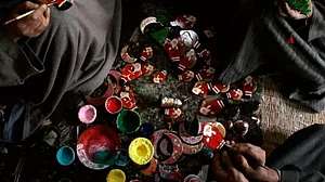 Kashmiri Muslim artisans paint the final touches to products before sending them for Christmas