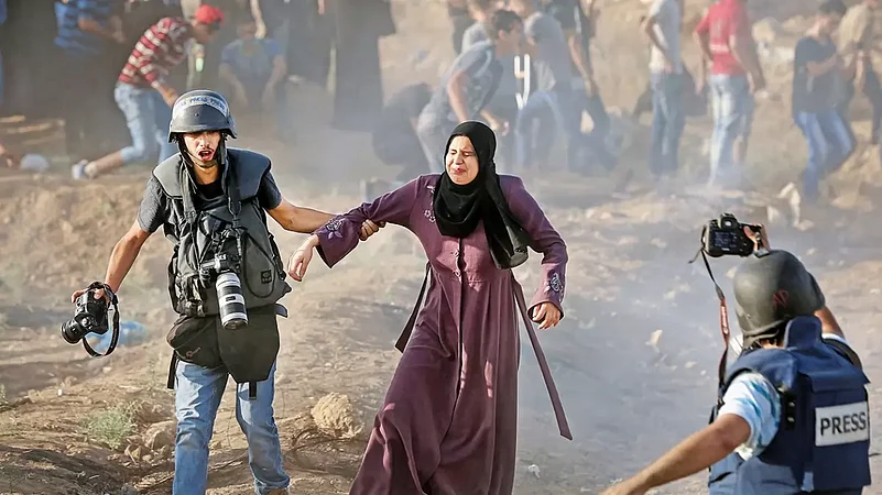 press photographer rescues a woman from tear gas at a protest in Gaza