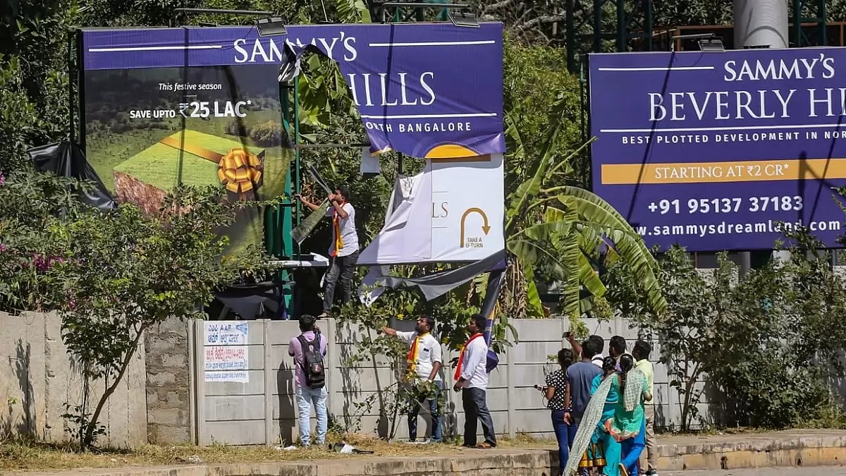  A billboard being vandalised by Karnataka Rakshana Vedike activists in Bengaluru