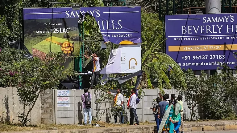 A billboard being vandalised by Karnataka Rakshana Vedike activists in Bengaluru - null