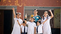 A school teacher with her students holding trophy and celebrating victory