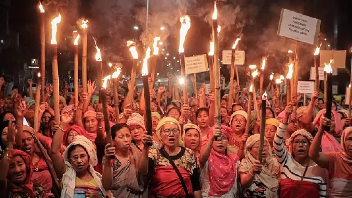 A group of women representing Meitei society, hold torches during a demonstration - File Photo
