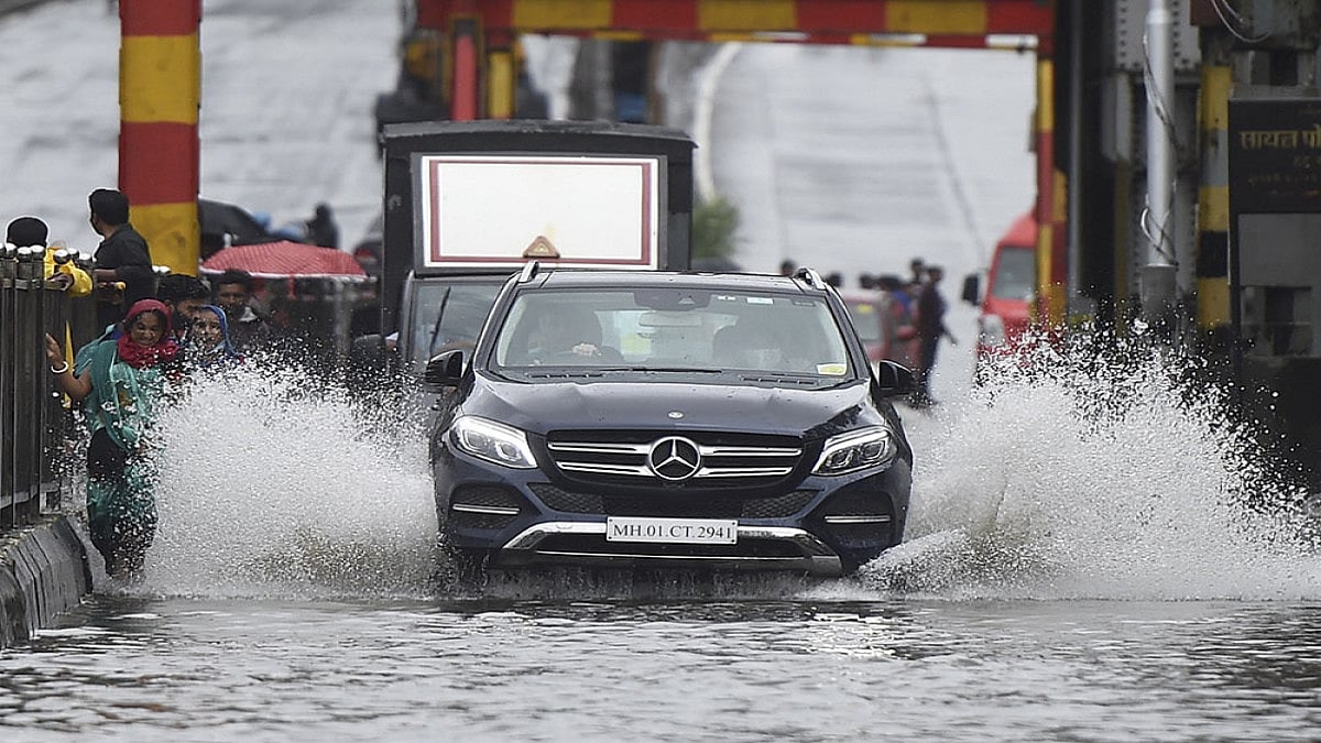 A car wades through a waterlogged street as heavy rain continues, at Sion in Mumbai. - null