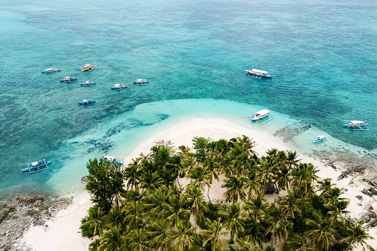 Shutterstock : Turquoise waters and boats at Guyam Island, Siargao.