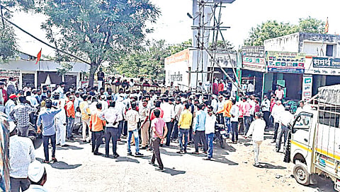 लासलगाव : बाजार समितीच्या मुख्य प्रवेशद्वारावर एकत्र येत कांदा लिलाव बंद पाडताना शेतकरी. 