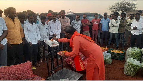 पिंपळनेर :  किसान क्रांती भाजीपाला मार्केटच्या उद्घाटनप्रसंगी वजनकाट्याची पूजा करताना नागाई येथील महंत श्री १००८ प्रणव गिरीजा बाबाजी. समवेत शेतकरी व ग्रामस्थ. (छाया:अंबादास बेनुस्कर)