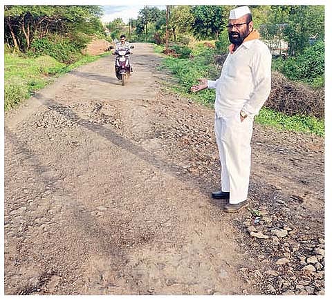 वडगाव काशिंबेग (ता. आंबेगाव) ते दत्त मंदिर रस्त्यावरील उखडलेली खडी दाखविताना ग्रामस्थ.