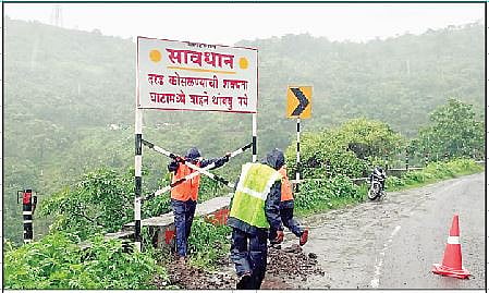 कात्रज घाटात दिशादर्शक फलक लावताना सार्वजनिक बांधकाम विभागाचे कर्मचारी.