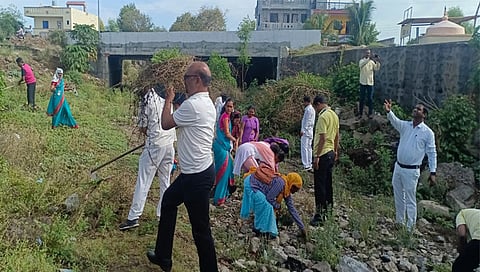 नांदगाव : गंगाधरी येथील नदी स्वच्छ करताना पंचायत समितीचे कर्मचारी. समवेत गटविकास आधिकारी गणेश  चौधरी. (छाया : सचिन बैरागी)   