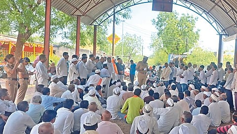 मालेगाव : मतदानावर बहिष्कार टाकलेल्या मेहुणे ग्रामस्थांशी चर्चा करताना तालुका पोलिस ठाण्याचे प्रभारी अधिकारी राहुल खताळ. दुसर्‍या छायाचित्रात मराठी शाळेत असलेल्या तिन्ही मतदान केंद्रांवरील शुकशुकाट. (छाया : नीलेश शिंपी)