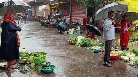 पूर्णा येथे भरपावसात भाजीपाला विकताना  विक्रेते  