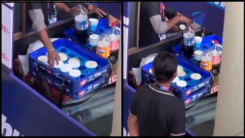 staff collecting liquid from and pouring it into containers amid bottle in delhi stadium