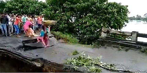 வெள்ளத்தில் அ‌டித்துச்செல்லப்பட்ட பாலம்: 3 பேர் தத்தளிப்பு