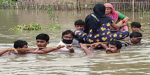 கழுத்தளவு தண்ணீரில் சிக்கிய கர்ப்பிணி – மரக்கட்டை, டயர்களால் ஆன படகில் மீட்ட மக்கள்