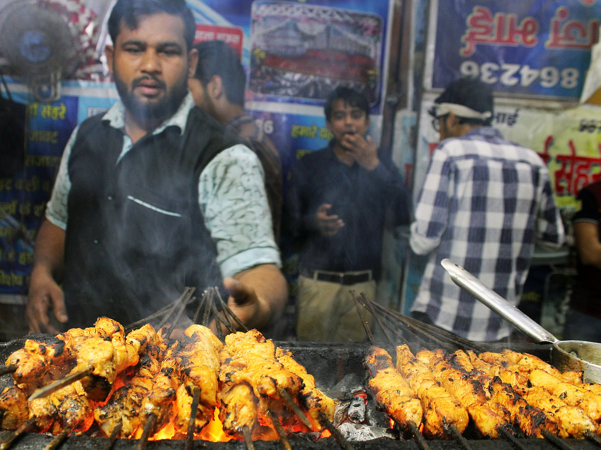 کباب تیار کیے جانے کا منظر اور کباب کا مزہ لیتے ہوئے نوجوان لڑکے (تصویر قومی آواز)