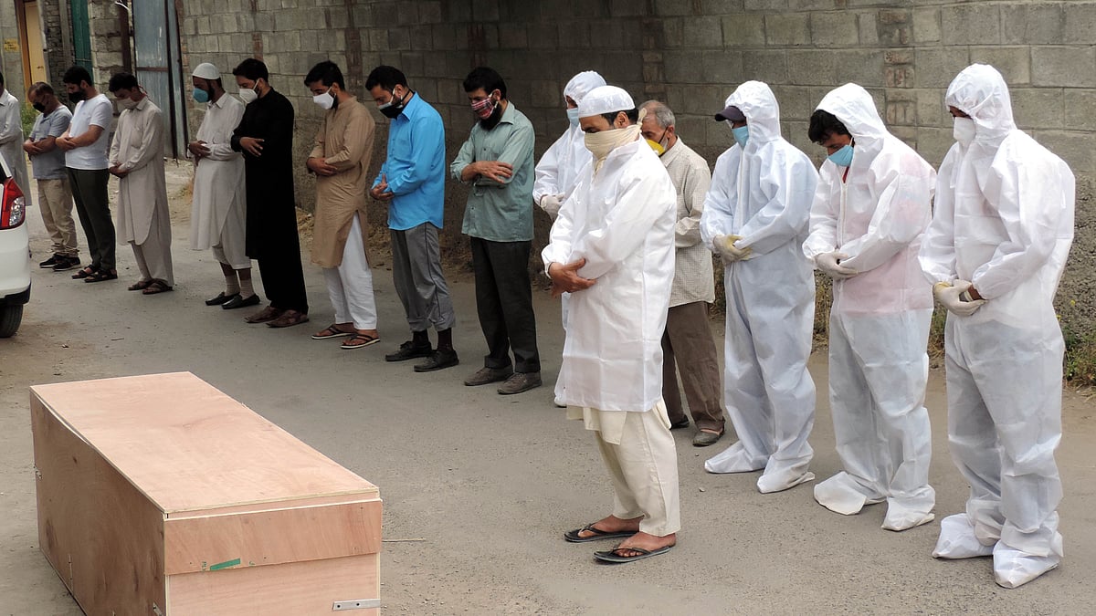 کشمیر: کورونا سے وفات پانے والے مریض کی نماز جنازہ ادا کرتے فرزندان توحید / UNI