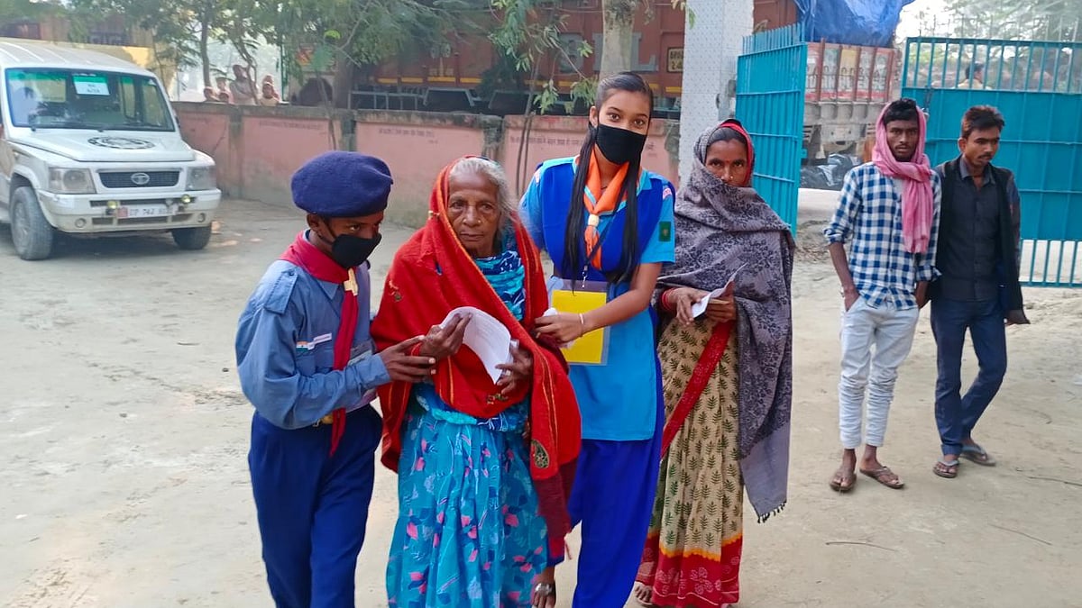 ویشالی میں عمر رسیدہ خاتون کی ووٹ دینے میں مدد کرتے اسکاؤٹ اینڈ گائیڈ کے رضاکار / @CEOBihar