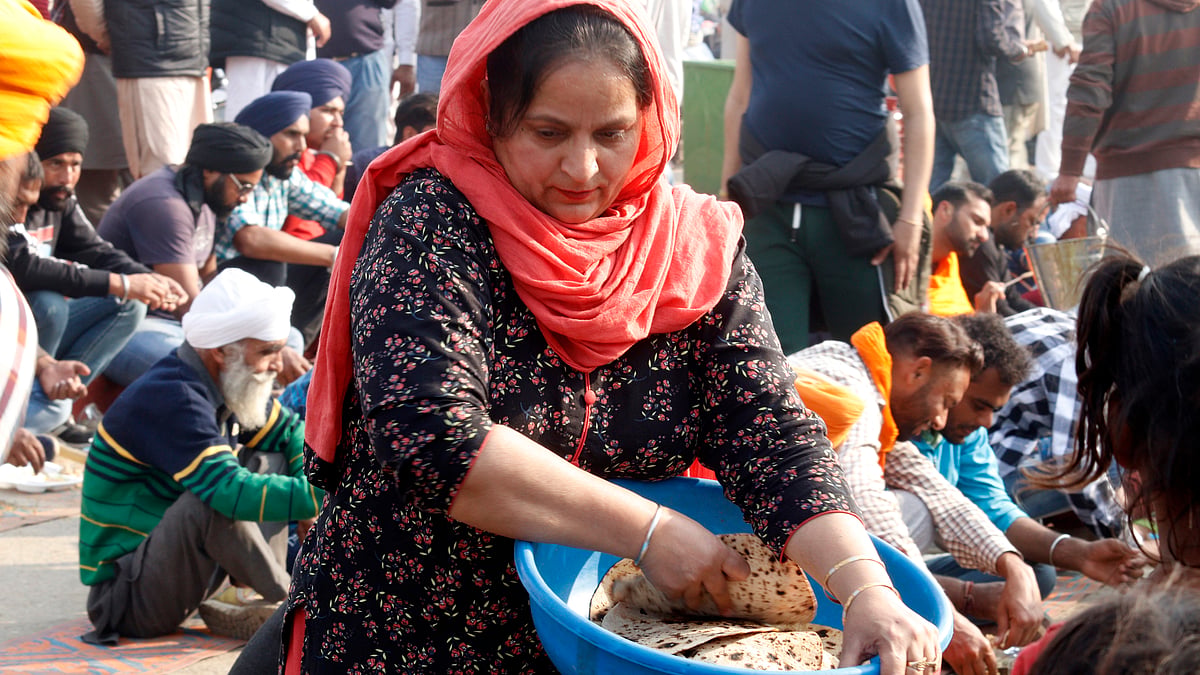 کسان تحریک کے دوران مظاہرین کو کھانا پیش کرتی خاتون / Getty Images