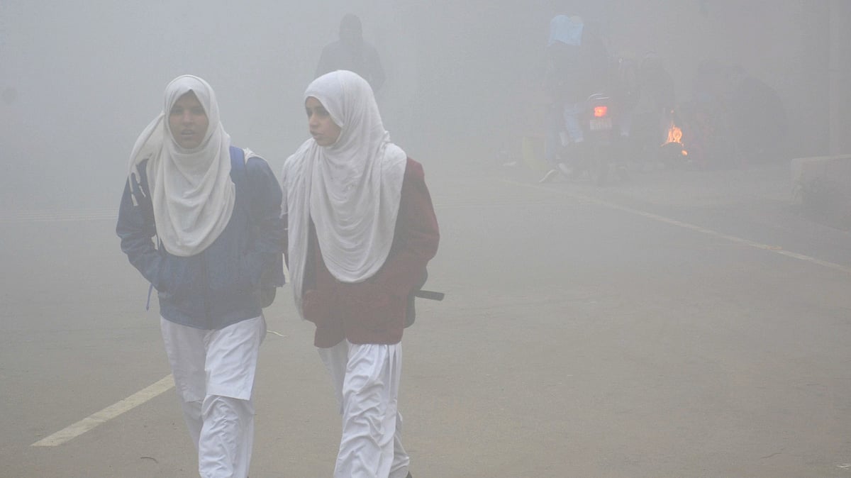 غازی آباد میں سردی اور گھنی دھند کے درمیان اسکول کے لئے روانہ ہوتیں بچیاں / Getty Images