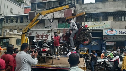 पोलिसांनी गाडी सकट दुचाकीस्वाराला भरले टेम्पोत