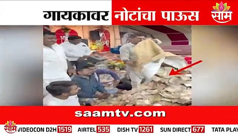 Audience showers bundles of cash on a singer during a live event in Khambhaliya, Gujarat.