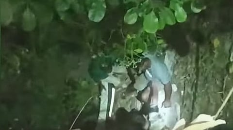 താഴ്ചയിലേക്ക് മറിഞ്ഞ കാറില്‍ നിന്ന് യാത്രക്കാരെ രക്ഷിക്കുന്നു