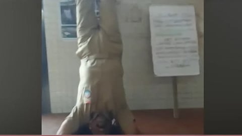 ജീവനക്കാരൻ തലകുത്തി നിന്ന് പ്രതിഷേധിക്കുന്നു 