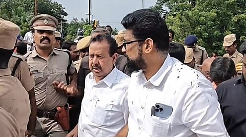 ചെളി വാരിയെറിഞ്ഞതിനെത്തുടര്‍ന്ന് മന്ത്രിയെ വാഹനത്തില്‍ കയറ്റാന്‍ ശ്രമിക്കുന്ന പൊലീസുകാര്‍