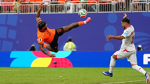 Netherlands' Memphis Depay tries to reach the ball in front of Tunisia's Mohamed Hadj Mahmoud